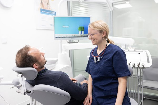 Oralchirurgin informiert Patient über anstehende OP